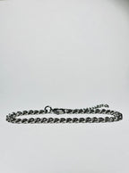 Rövid láncszemes arany nyaklánc és hozzá illő láncszemes karlánc fehér háttéren, letisztult és elegáns megjelenéssel.