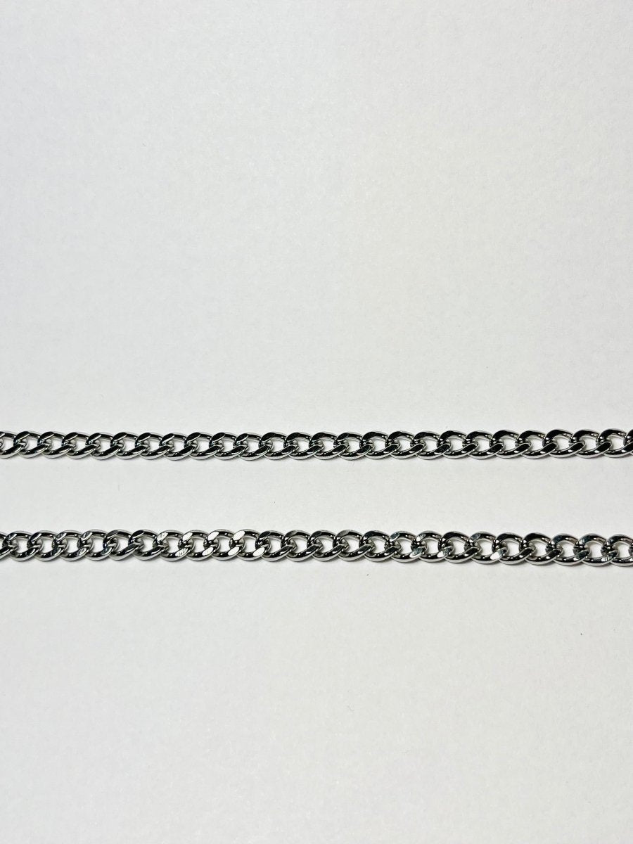 Rövid láncszemes arany nyaklánc és hozzá illő láncszemes karlánc fehér háttéren, letisztult és elegáns megjelenéssel.