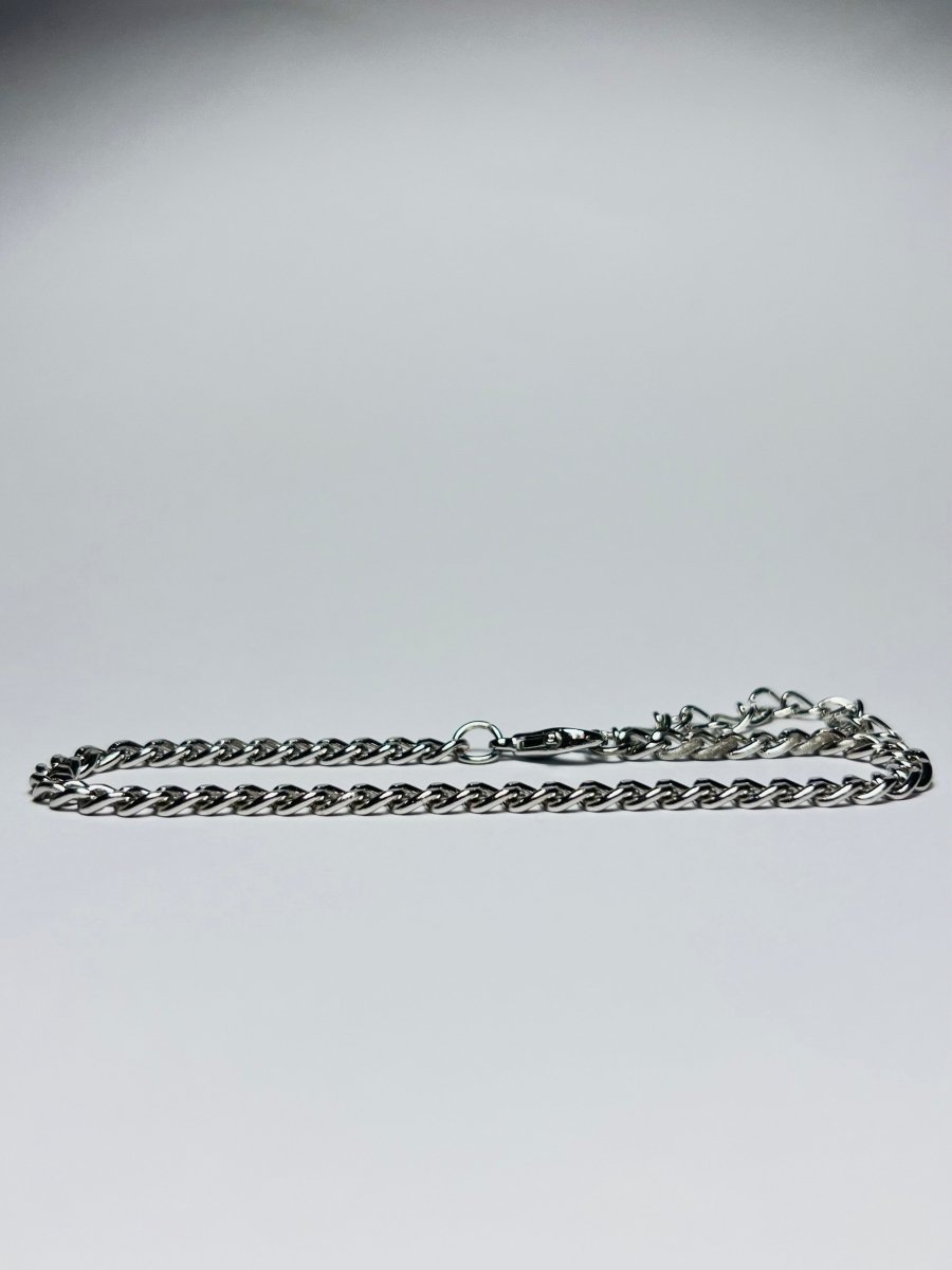 Aranyozott rövid láncszemes nyaklánc fehér háttéren, fényes felülettel és letisztult, elegáns megjelenéssel.