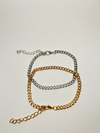 Aranyozott rövid láncszemes nyaklánc fehér háttéren, fényes felülettel és letisztult, elegáns megjelenéssel.