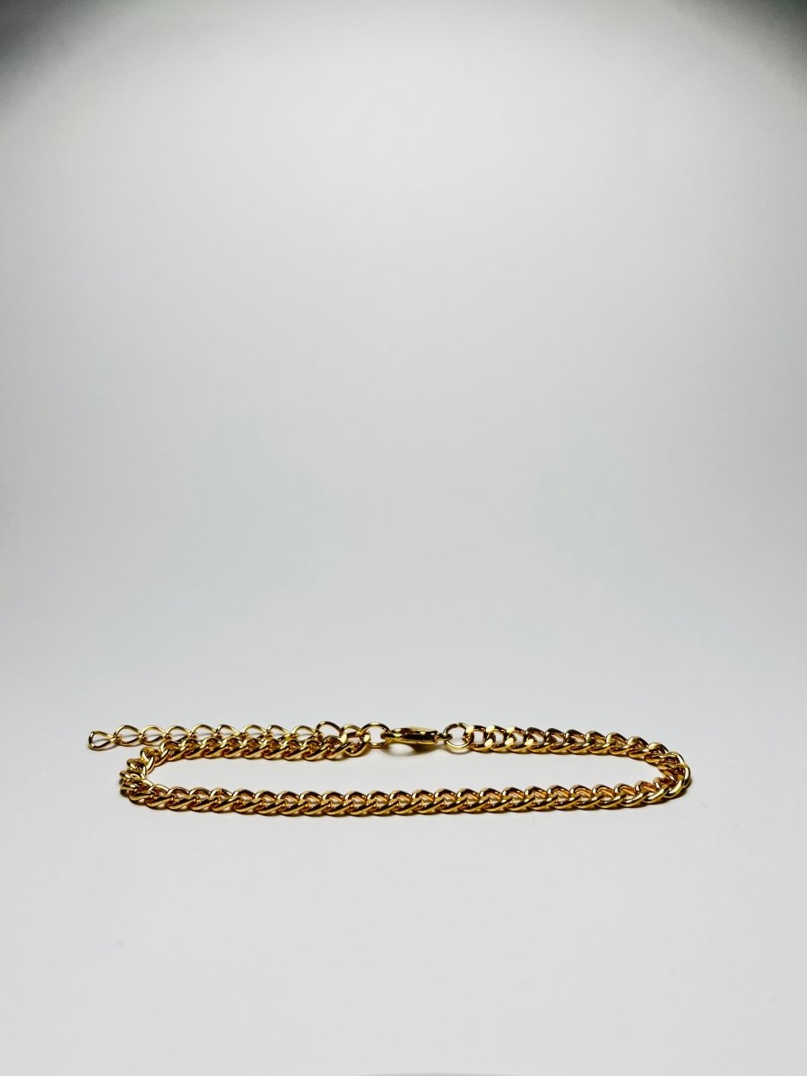 Aranyozott rövid láncszemes nyaklánc fehér háttéren, fényes felülettel és letisztult, elegáns megjelenéssel.