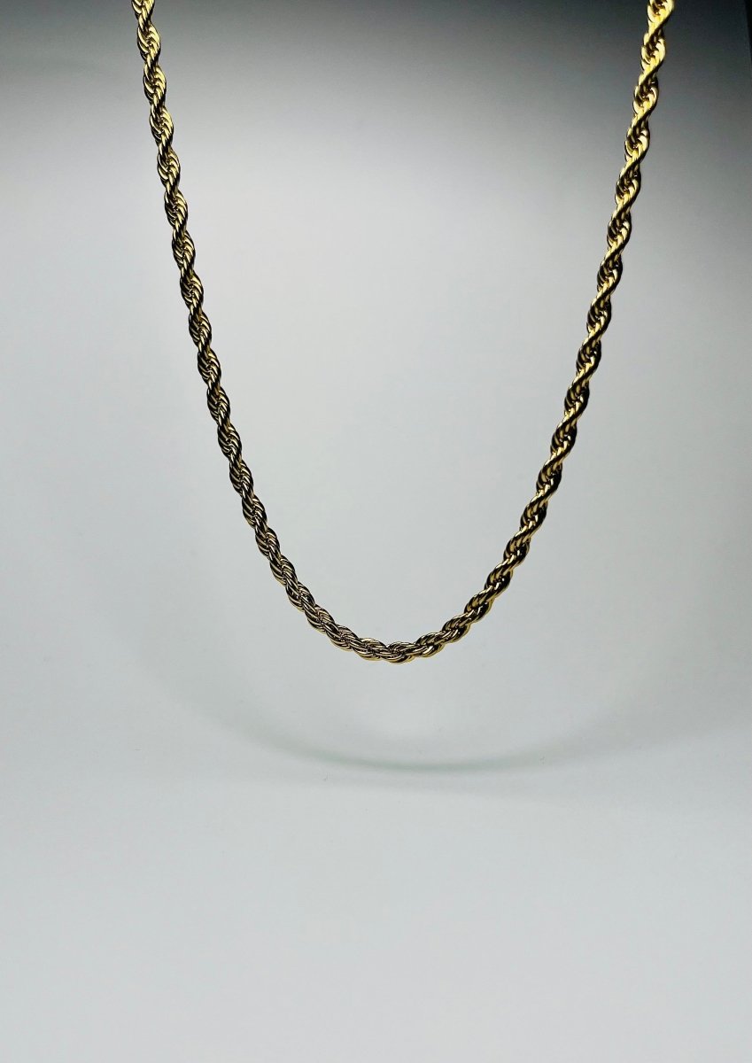 Aranyozott csavart láncszemes nyaklánc fehér háttéren, fényes felülettel és letisztult, elegáns megjelenéssel.