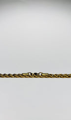 Aranyozott csavart láncszemes nyaklánc fehér háttéren, fényes felülettel és letisztult, elegáns megjelenéssel.