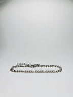 Aranyozott hosszú-rövid láncszemes karlánc fehér háttéren, fényes felülettel és letisztult, elegáns megjelenéssel.