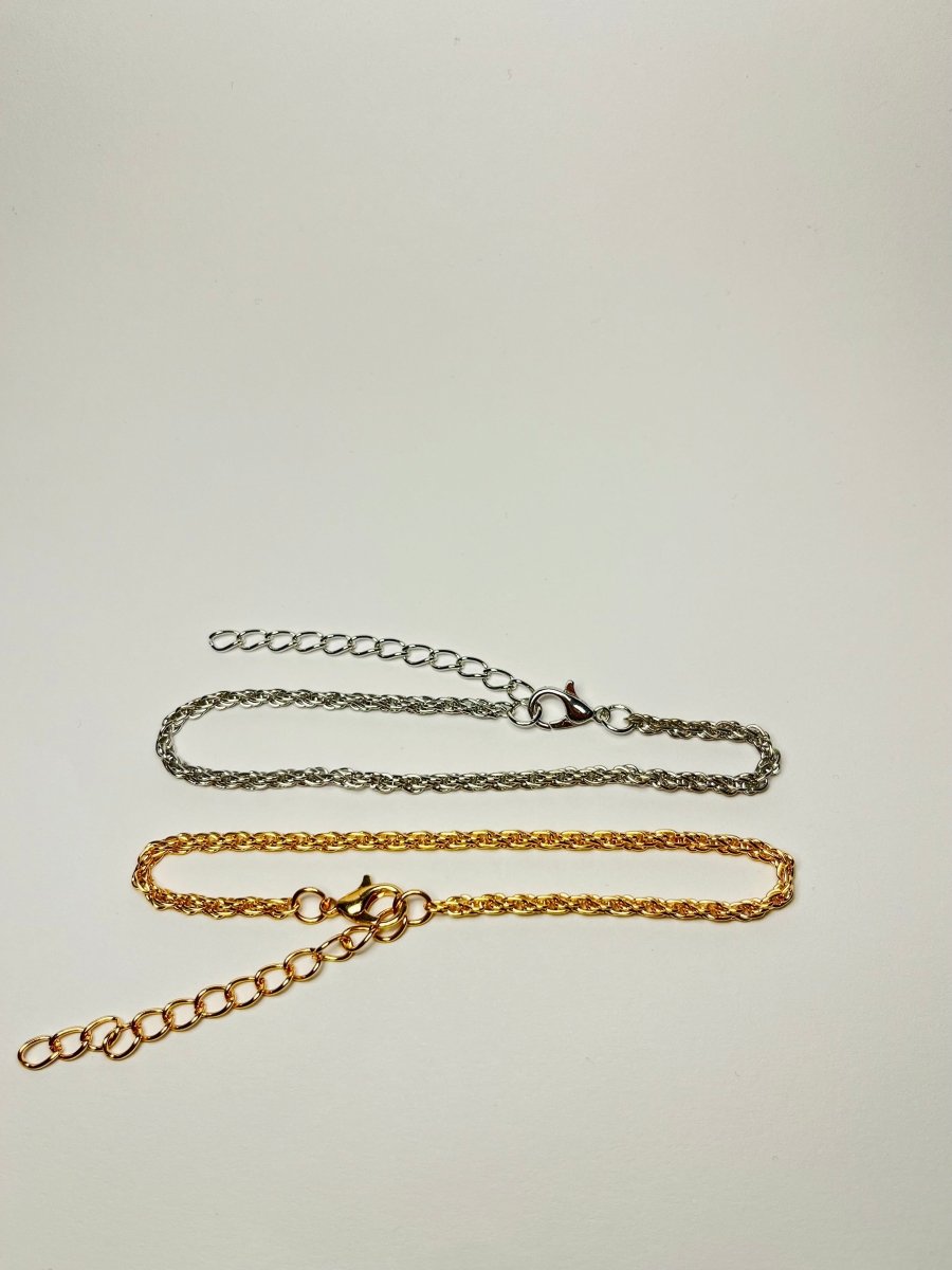 Aranyozott csavart láncszemes karlánc fehér háttéren, fényes felülettel és letisztult, elegáns megjelenéssel.