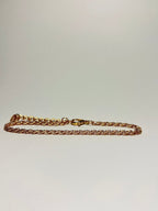 Aranyozott csavart láncszemes karlánc fehér háttéren, fényes felülettel és letisztult, elegáns megjelenéssel.