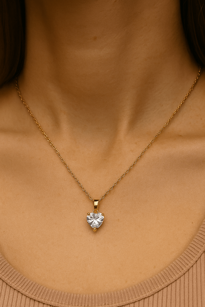 Szív alakú aranyozott medálos nyaklánc egy nő nyakán, természetes fényben, elegáns, visszafogott megjelenéssel.