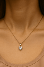 Szív alakú aranyozott medálos nyaklánc egy nő nyakán, természetes fényben, elegáns, visszafogott megjelenéssel.