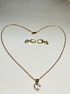 Aranyozott nemesacél szív medálos nyaklánc fehér háttéren, finom, fényes lánccal és letisztult megjelenéssel. Aranyozott szív alakú fülbevaló pár fehér háttéren, fényes felülettel, finom és nőies stílusban.